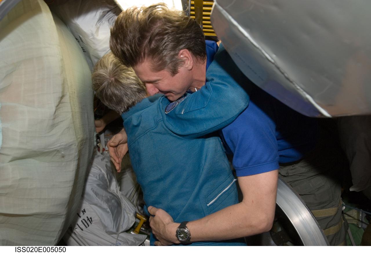ISS020-E-005050 (29 May 2009) --- Cosmonaut Gennady Padalka (right), Expedition 19/20 commander, welcomes Canadian Space Agency astronaut Robert Thirsk, Expedition 20/21 flight engineer, after Thirsk arrived onboard a Soyuz TMA-15 spacecraft with European Space Agency astronaut Frank De Winne (out of frame) and cosmonaut Roman Romanenko (out of frame), both flight engineers. The crew launched from the Baikonur Cosmodrome in Kazakhstan at 5:34 a.m. (CDT), May 27, 2009, and arrived at the station at 7:34 a.m. (CDT) on May 29, beginning Expedition 20 and six-person crew operations.