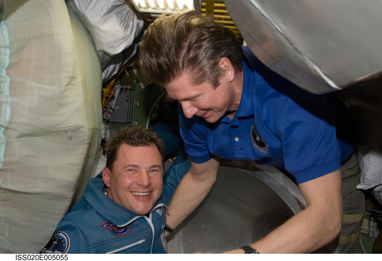 ISS020-E-005055 (29 May 2009) --- Cosmonaut Gennady Padalka (right), Expedition 19/20 commander, welcomes cosmonaut Roman Romanenko, Expedition 20/21 flight engineer, after Romanenko arrived onboard a Soyuz TMA-15 spacecraft with European Space Agency astronaut Frank De Winne (out of frame) and Canadian Space Agency astronaut Robert Thirsk (out of frame), both flight engineers. The crew launched from the Baikonur Cosmodrome in Kazakhstan at 5:34 a.m. (CDT), May 27, 2009, and arrived at the station at 7:34 a.m. (CDT) on May 29, beginning Expedition 20 and six-person crew operations.