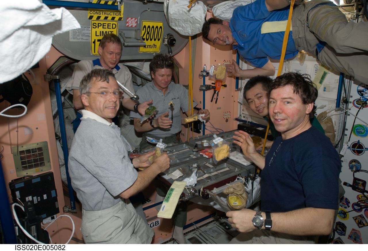 ISS020-E-005082 (30 May 2009) --- The Expedition 20 crew members share a meal in the Unity node of the International Space Station. Pictured (from the left, clockwise) are Canadian Space Agency astronaut Robert Thirsk, European Space Agency astronaut Frank De Winne, both flight engineers; cosmonaut Gennady Padalka, commander; cosmonaut Roman Romanenko, Japan Aerospace Exploration Agency (JAXA) astronaut Koichi Wakata and NASA astronaut Michael Barratt, all flight engineers.