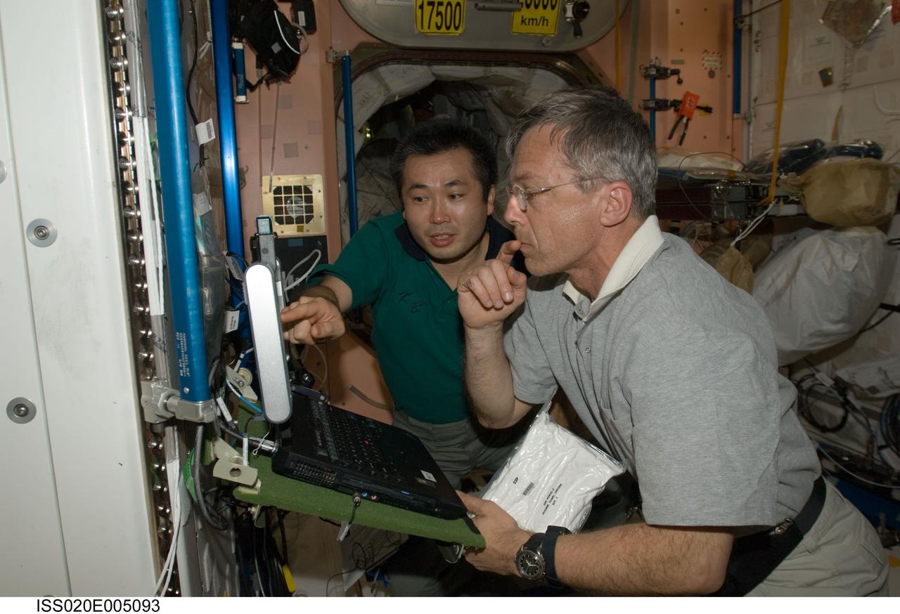 ISS020-E-005093 (30 May 2009) --- Canadian Space Agency astronaut Robert Thirsk (foreground) and Japan Aerospace Exploration Agency (JAXA) astronaut Koichi Wakata, both Expedition 20 flight engineers, work in the Unity node of the International Space Station.