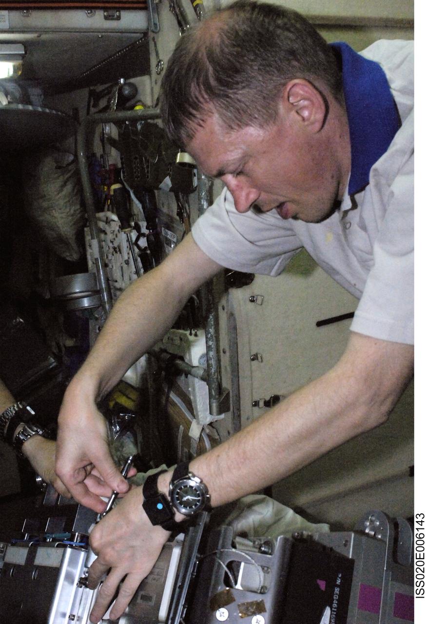 ISS020-E-006143 (3 June 2009) --- European Space Agency astronaut Frank De Winne, Expedition 20 flight engineer, performs in-flight maintenance on the Treadmill Vibration Isolation System (TVIS) in the Zvezda Service Module of the International Space Station.