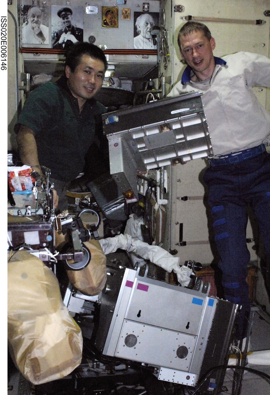 ISS020-E-006146 (3 June 2009) --- Japan Aerospace Exploration Agency (JAXA) astronaut Koichi Wakata (left) and European Space Agency astronaut Frank De Winne, both Expedition 20 flight engineers, perform in-flight maintenance on the Treadmill Vibration Isolation System (TVIS) in the Zvezda Service Module of the International Space Station.