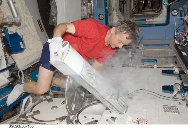 NASA image: Thirsk inserts samples into MELFI in the JPM