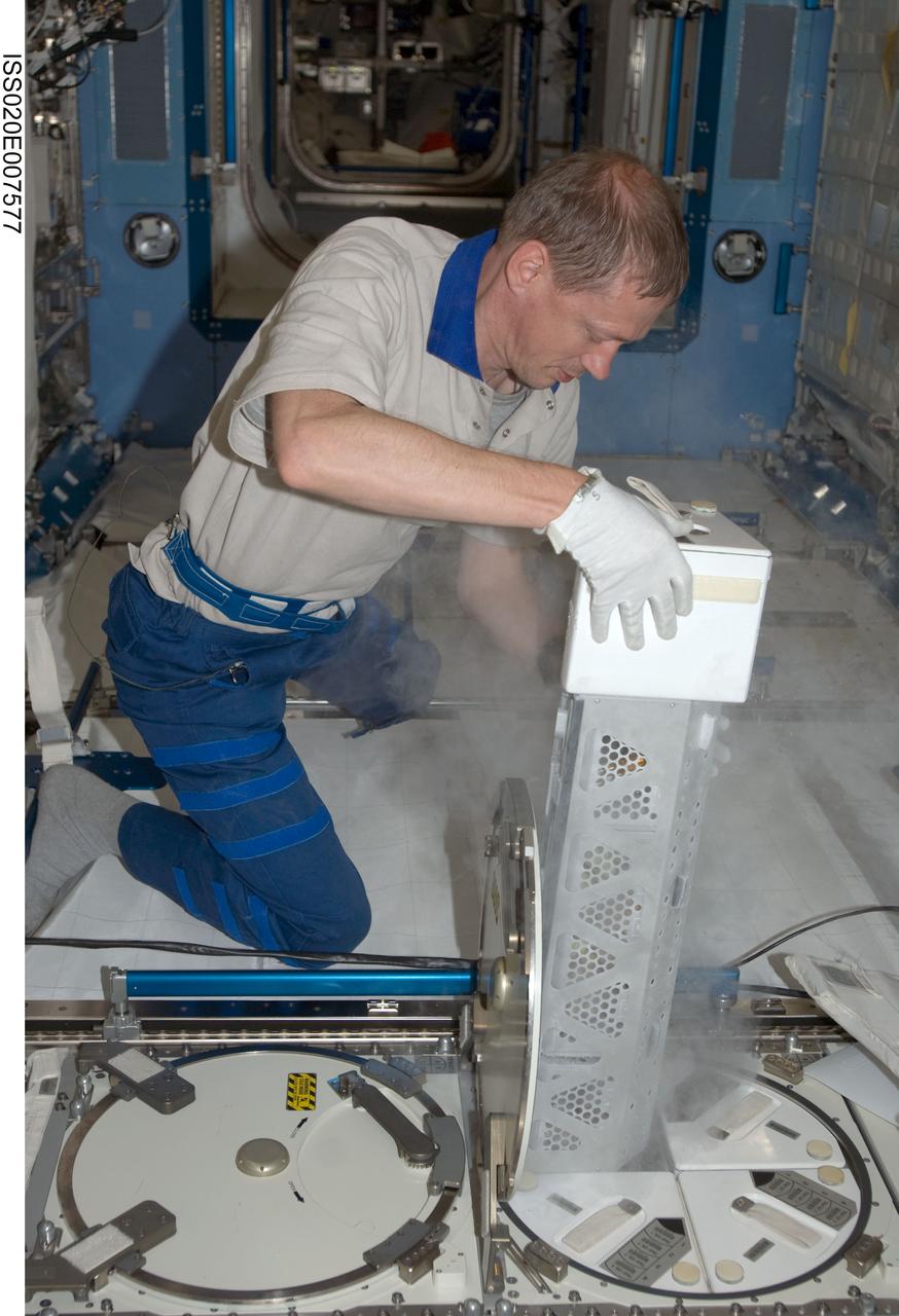 ISS020-E-007577 (6 June 2009) --- European Space Agency astronaut Frank De Winne, Expedition 20 flight engineer, returns a dewar tray to the Minus Eighty Laboratory Freezer for ISS (MELFI) after inserting biological samples into the trays in the Kibo laboratory of the International Space Station. Samples were taken as part of the Nutritional Status Assessment (Nutrition) with Repository experiment, a study done by NASA to date of human physiologic changes during long-duration spaceflight.
