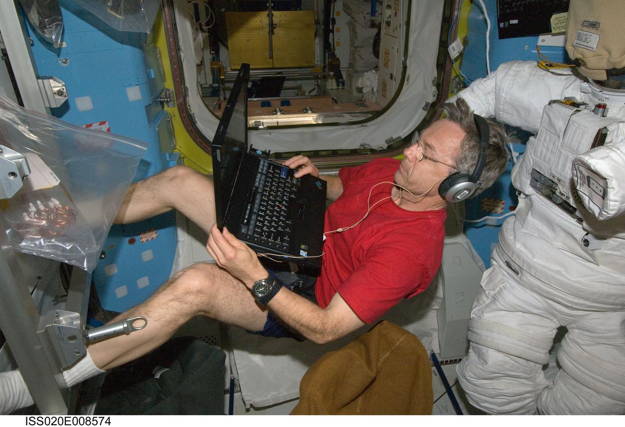 ISS020-E-008574 (11 June 2009) --- Canadian Space Agency astronaut Robert Thirsk, Expedition 20 flight engineer, uses a computer in the Quest airlock of the International Space Station.