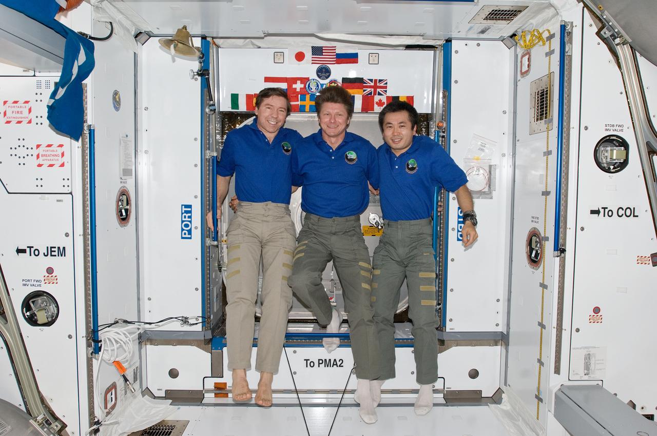 ISS020-E-008879 (14 June 2009) --- Cosmonaut Gennady Padalka (center), Expedition 19/20 commander; along with NASA astronaut Michael Barratt (left) and Japan Aerospace Exploration Agency (JAXA) astronaut Koichi Wakata, both Expedition 19/20 flight engineers, pose for a photo in the Harmony node of the International Space Station.