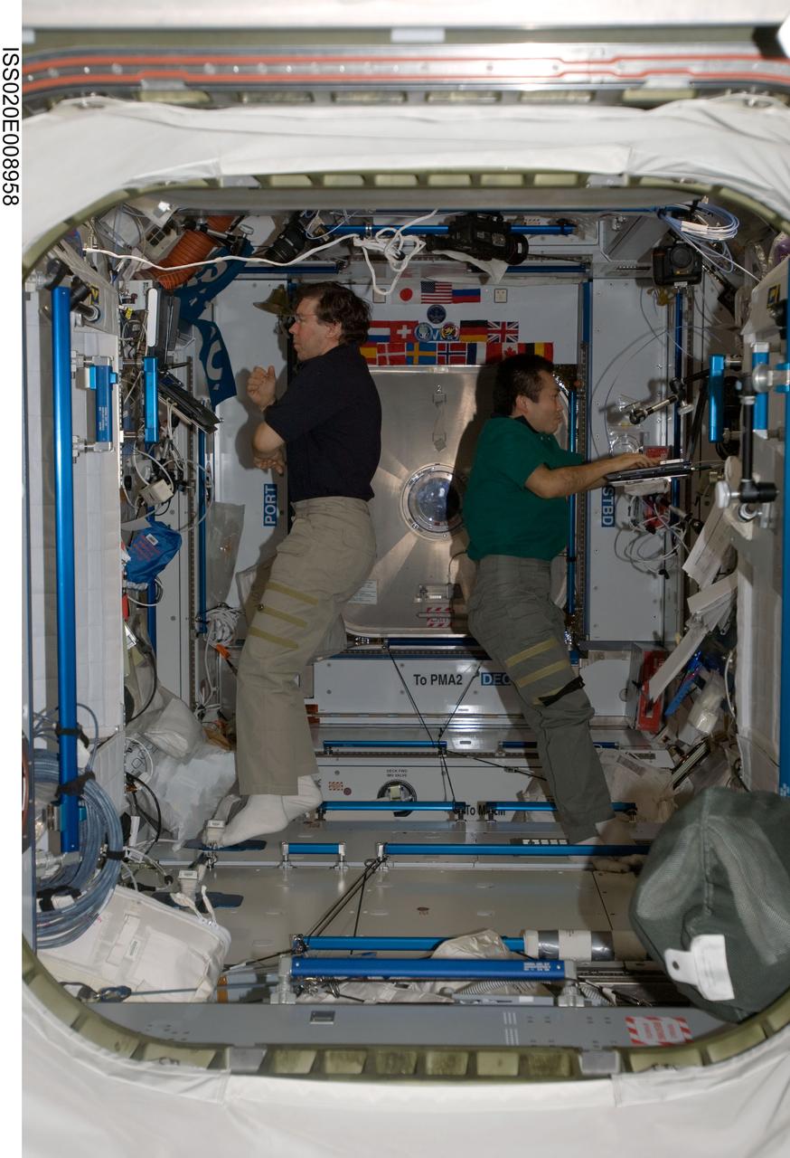 ISS020-E-008958 (14 June 2009) --- NASA astronaut Michael Barratt (left) and Japan Aerospace Exploration Agency (JAXA) astronaut Koichi Wakata, both Expedition 20 flight engineers, work in the Harmony node of the International Space Station.