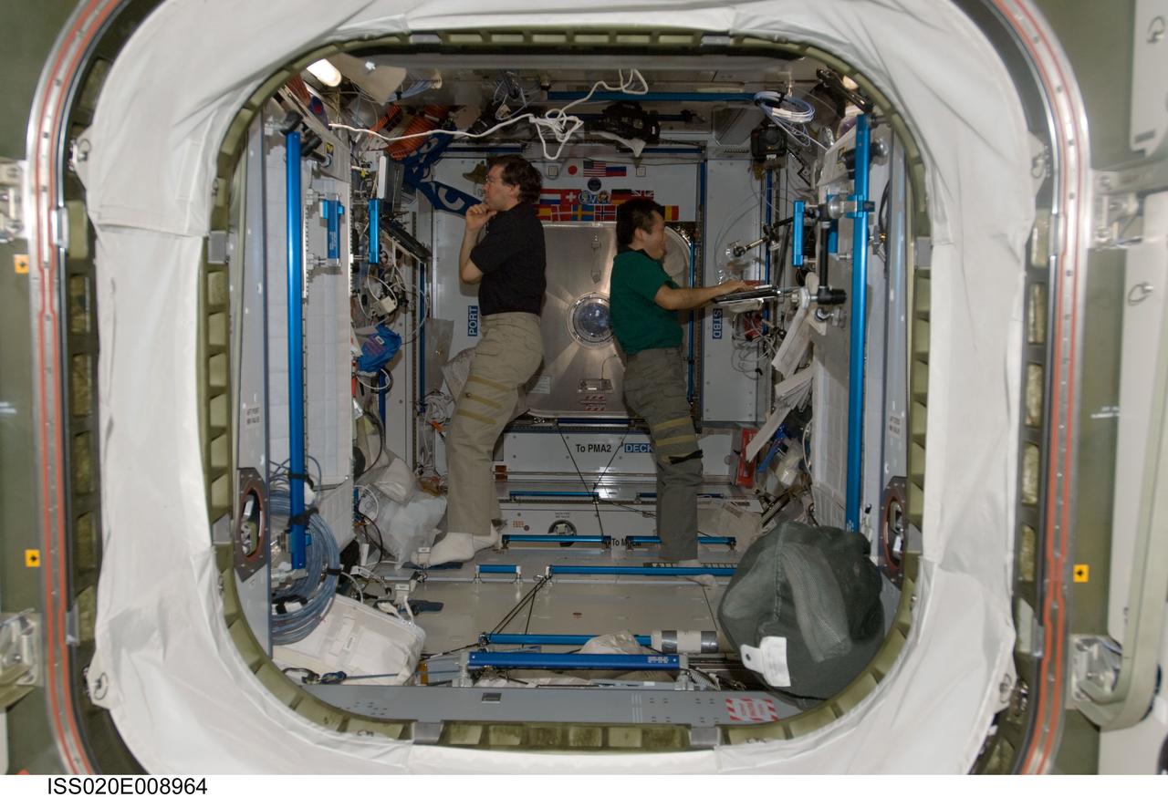 ISS020-E-008964 (14 June 2009) --- NASA astronaut Michael Barratt (left) and Japan Aerospace Exploration Agency (JAXA) astronaut Koichi Wakata, both Expedition 20 flight engineers, work in the Harmony node of the International Space Station.
