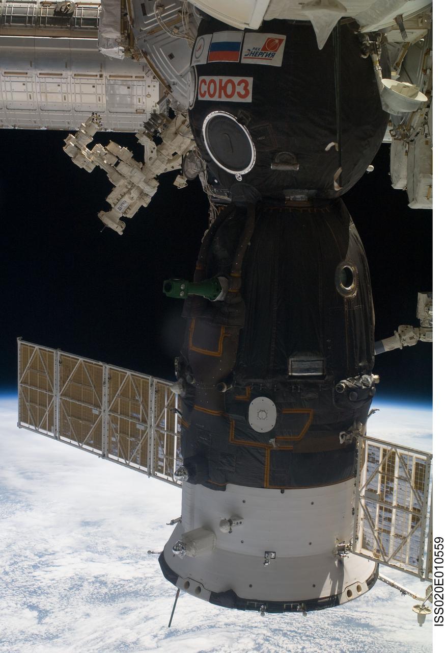 ISS020-E-010559 (16 June 2009) --- A Soyuz spacecraft docked with the International Space Station, the Canadian-built Dextre, also known as the Special Purpose Dextrous Manipulator (top left) and a portion of the Japanese Kibo laboratory (upper left corner) are featured in this image photographed by an Expedition 20 crew member on the station. The blackness of space and Earth’s horizon provide the backdrop for the scene.