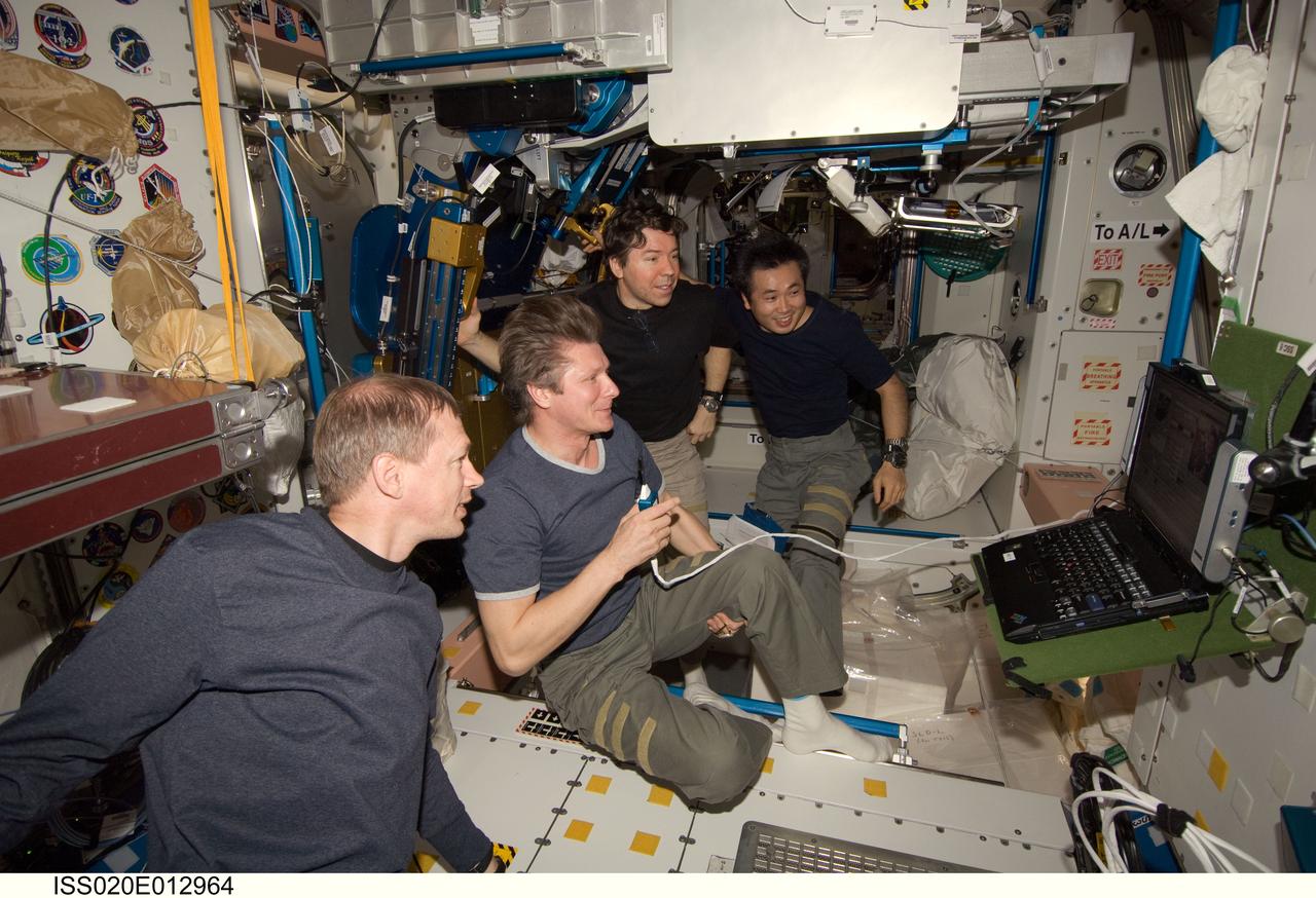 ISS020-E-012964 (21 June 2009) --- Expedition 20 crew members view a monitor in the International Space Station’s Unity node as they celebrate Father’s Day and the birthday of cosmonaut Gennady Padalka (center), commander. Today also marked Japan Aerospace Exploration Agency (JAXA) astronaut Koichi Wakata’s (right background) 100th day in orbit since his launch to the ISS aboard the Space Shuttle Discovery in March. Also pictured are European Space Agency astronaut Frank De Winne (foreground) and NASA astronaut Michael Barratt (left background), both flight engineers.
