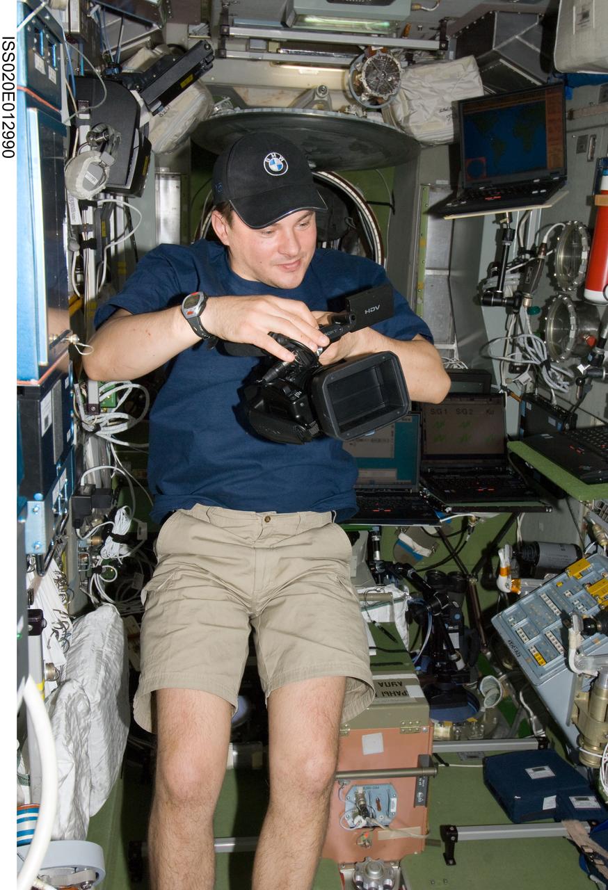 ISS020-E-012990 (21 June 2009) --- Cosmonaut Roman Romanenko, Expedition 20 flight engineer, prepares to use a High Definition Video (HDV) camera in the Zvezda Service Module of the International Space Station.