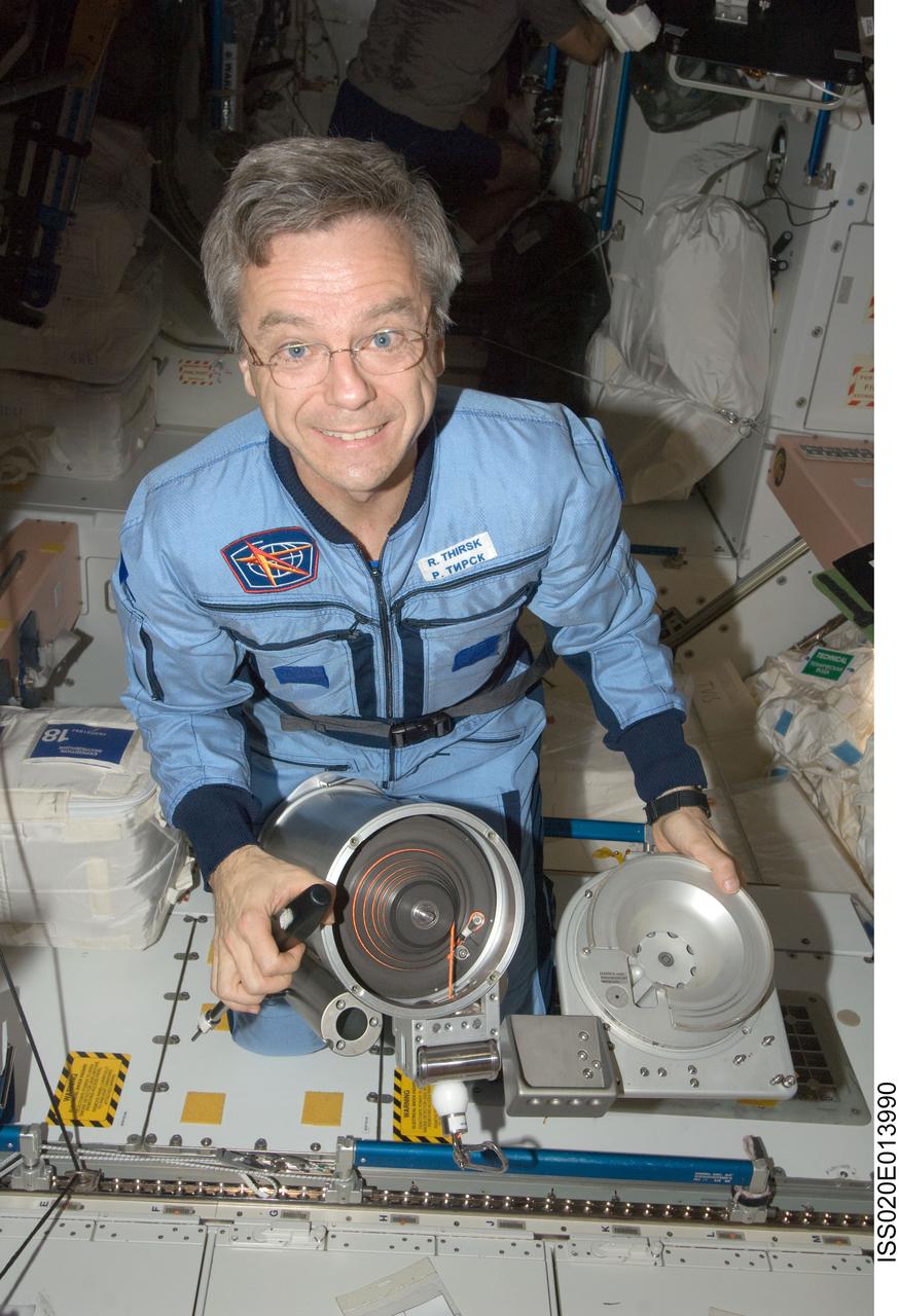 ISS020-E-013990 (23 June 2009) --- Canadian Space Agency astronaut Robert Thirsk, Expedition 20 flight engineer, performs in-flight maintenance on a cable cartridge for the advanced Resistive Exercise Device (aRED) in the Unity node of the International Space Station.