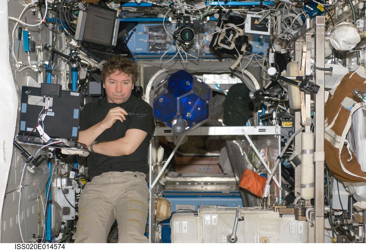 ISS020-E-014574 (26 June 2009) --- NASA astronaut Michael Barratt, Expedition 20 flight engineer, does a check of the Synchronized Position Hold, Engage, Reorient, Experimental Satellites (SPHERES) Beacon / Beacon Tester in the Destiny laboratory of the International Space Station.
