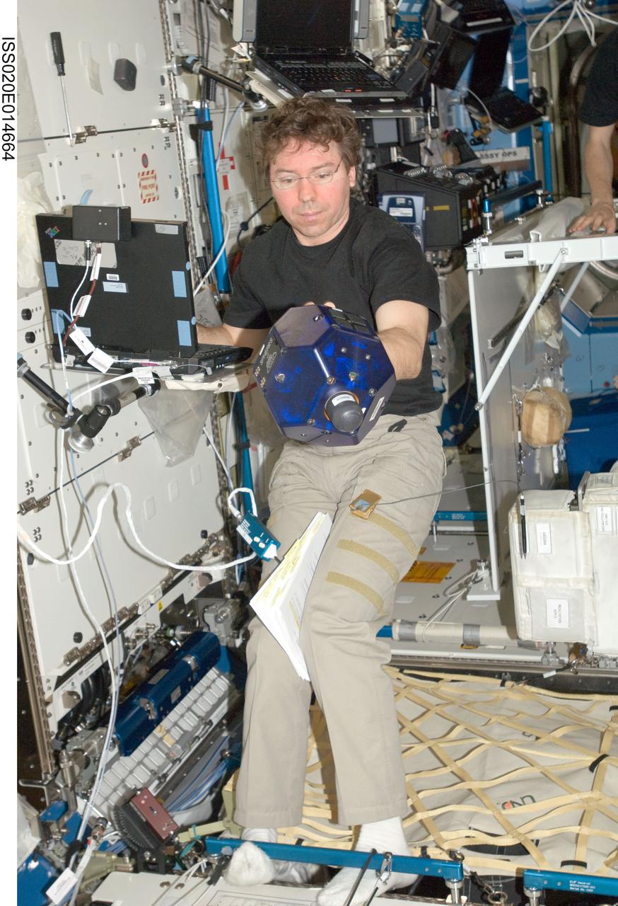 ISS020-E-014664 (26 June 2009) --- NASA astronaut Michael Barratt, Expedition 20 flight engineer, does a check of the Synchronized Position Hold, Engage, Reorient, Experimental Satellites (SPHERES) Beacon / Beacon Tester in the Destiny laboratory of the International Space Station.