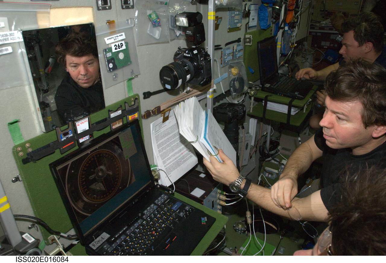 ISS020-E-016084 (1 July 2009) --- NASA astronaut Michael Barratt, Expedition 20 flight engineer, uses an onboard laptop-based simulator in the Zvezda Service Module of the International Space Station to prepare for the relocation of the Soyuz TMA-14 spacecraft from Zvezda?s aft port to the Pirs Docking Compartment on July 2, 2009. Cosmonaut Roman Romanenko, flight engineer, is visible in the background.