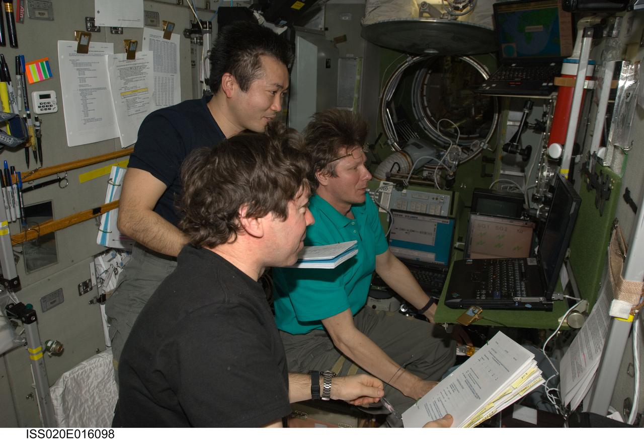 ISS020-E-016098 (1 July 2009) --- Cosmonaut Gennady Padalka (background), Expedition 20 commander; along with NASA astronaut Michael Barratt (foreground) and Japan Aerospace Exploration Agency (JAXA) astronaut Koichi Wakata, both flight engineers, use an onboard laptop-based simulator in the Zvezda Service Module of the International Space Station to prepare for the relocation of the Soyuz TMA-14 spacecraft from Zvezda?s aft port to the Pirs Docking Compartment. Padalka, Barratt and Wakata undocked the Soyuz spacecraft at 4:26 p.m. (CDT) and docked to the Pirs Docking Compartment at 4:54 p.m. on July 2, 2009.