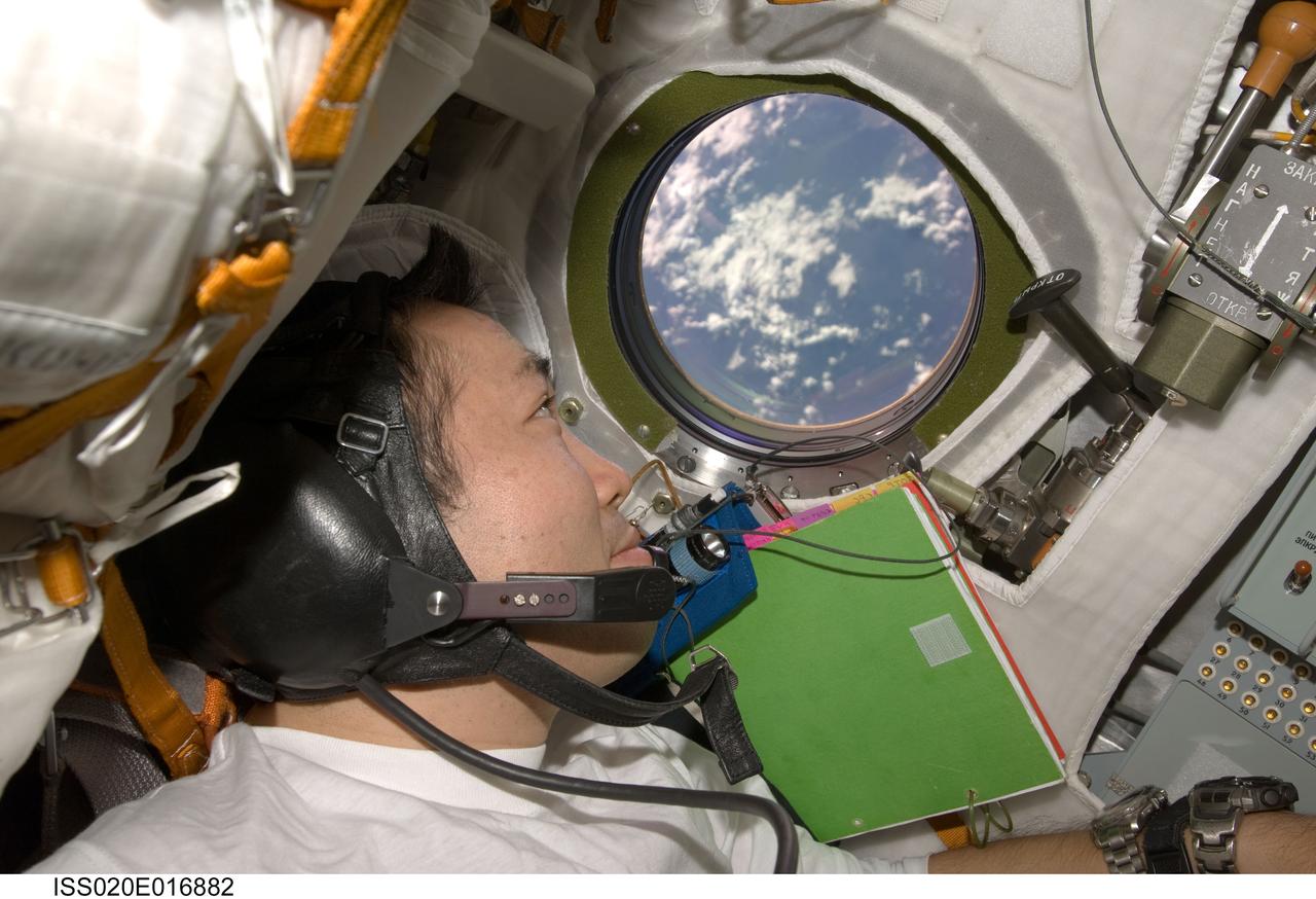 ISS020-E-016882 (2 July 2009) --- Japan Aerospace Exploration Agency (JAXA) astronaut Koichi Wakata, Expedition 20 flight engineer, looks through a window on the Soyuz TMA-14 spacecraft during preparations for the relocation of the Soyuz from the Zvezda Service Module’s aft port to the Pirs Docking Compartment of the International Space Station.