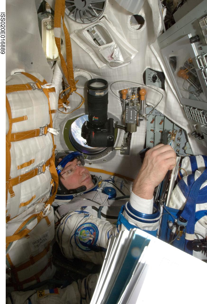 ISS020-E-016889 (2 July 2009) --- NASA astronaut Michael Barratt, Expedition 20 flight engineer, attired in a Russian Sokol launch and entry suit, occupies his seat in the Soyuz TMA-14 during final preparations for the relocation of the Soyuz from the Zvezda Service Module’s aft port to the Pirs Docking Compartment of the International Space Station.