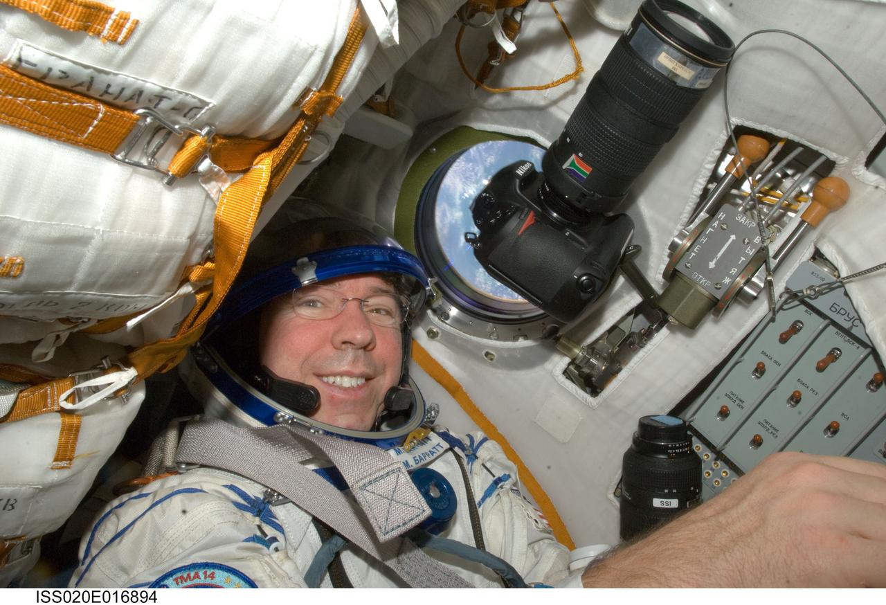 ISS020-E-016894 (2 July 2009) --- NASA astronaut Michael Barratt, Expedition 20 flight engineer, attired in a Russian Sokol launch and entry suit, occupies his seat in the Soyuz TMA-14 during final preparations for the relocation of the Soyuz from the Zvezda Service Module’s aft port to the Pirs Docking Compartment of the International Space Station.