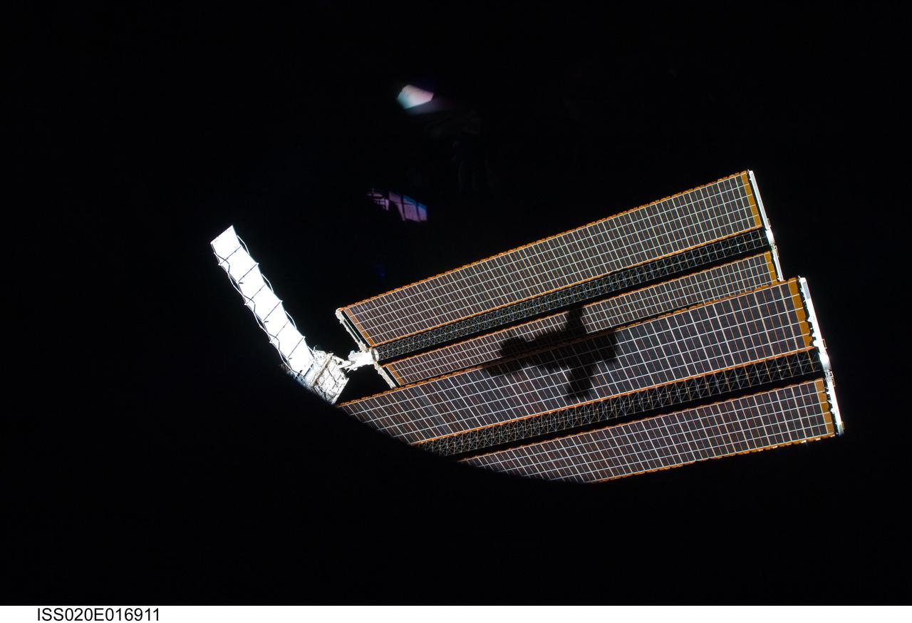 ISS020-E-016911 (2 July 2009) --- The shadow of the Soyuz TMA-14 spacecraft is visible against solar array panels of the International Space Station during the relocation of the Soyuz from the Zvezda Service Module’s aft port to the Pirs Docking Compartment. Cosmonaut Gennady Padalka, commander; along with NASA astronaut Michael Barratt and Japan Aerospace Exploration Agency (JAXA) astronaut Koichi Wakata, both flight engineers, undocked the Soyuz spacecraft at 4:26 p.m. (CDT) and docked to the Pirs Docking Compartment at 4:54 p.m. on July 2, 2009.