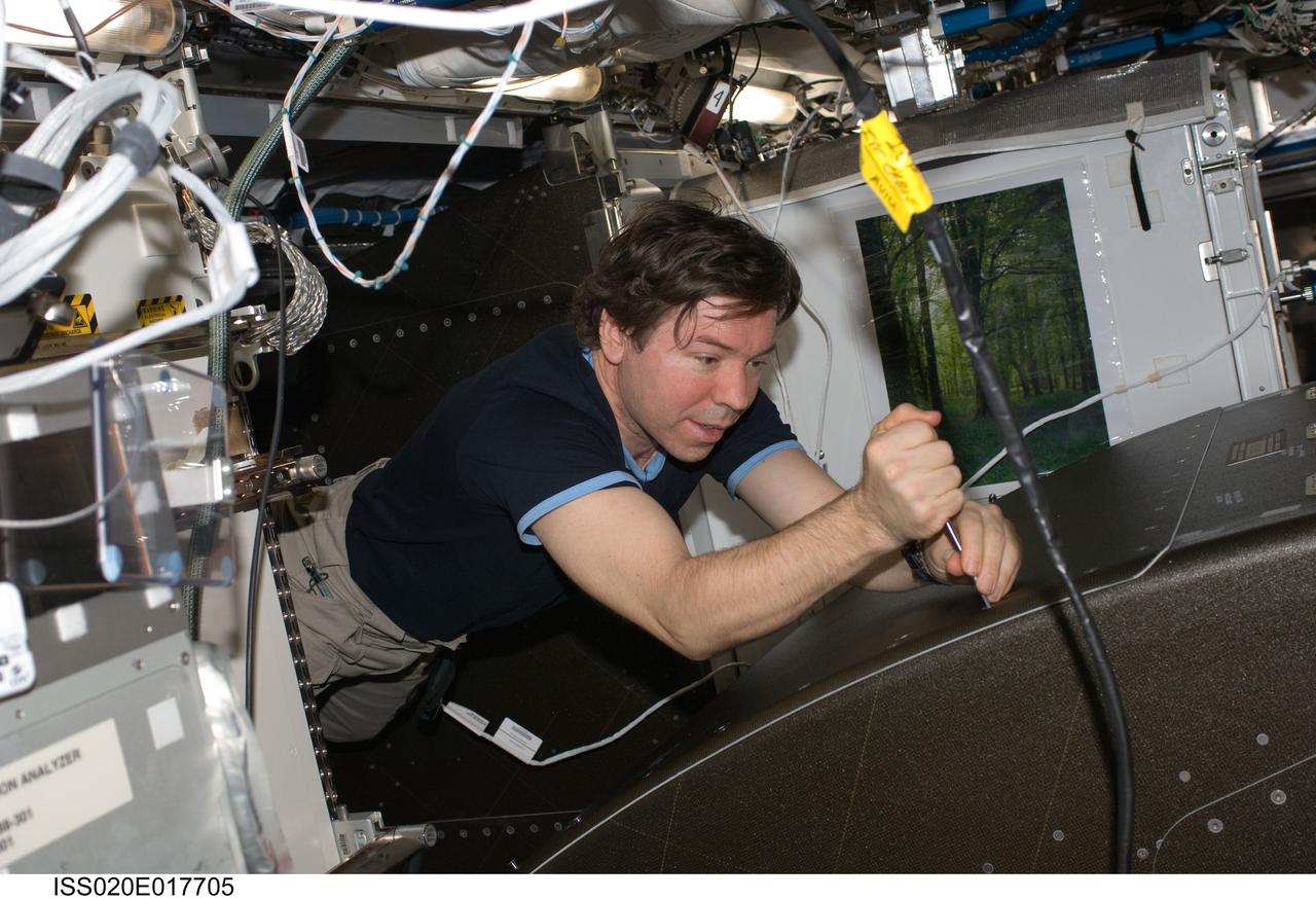 ISS020-E-017705 (7 July 2009) --- NASA astronaut Michael Barratt, Expedition 20 flight engineer, works at a rotated rack in the Destiny laboratory of the International Space Station during in-flight maintenance (IFM) to adjust the periodic flow rate of manual flow control valves for coolant loops.