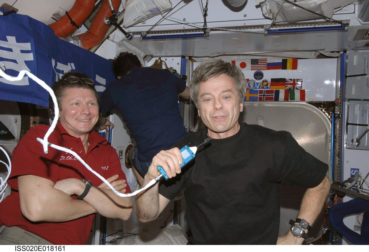 ISS020-E-018161 (10 July 2009) --- Canadian Space Agency astronaut Robert Thirsk, Expedition 20 flight engineer, uses a communication system in the Harmony node of the International Space Station. Also pictured are cosmonauts Gennady Padalka, commander, and Roman Romanenko (back to camera), flight engineer.