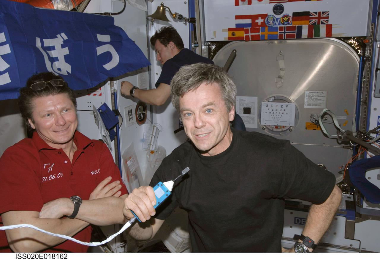 ISS020-E-018162 (10 July 2009) --- Canadian Space Agency astronaut Robert Thirsk, Expedition 20 flight engineer, uses a communication system in the Harmony node of the International Space Station. Also pictured are cosmonauts Gennady Padalka (left foreground), commander, and Roman Romanenko, flight engineer.