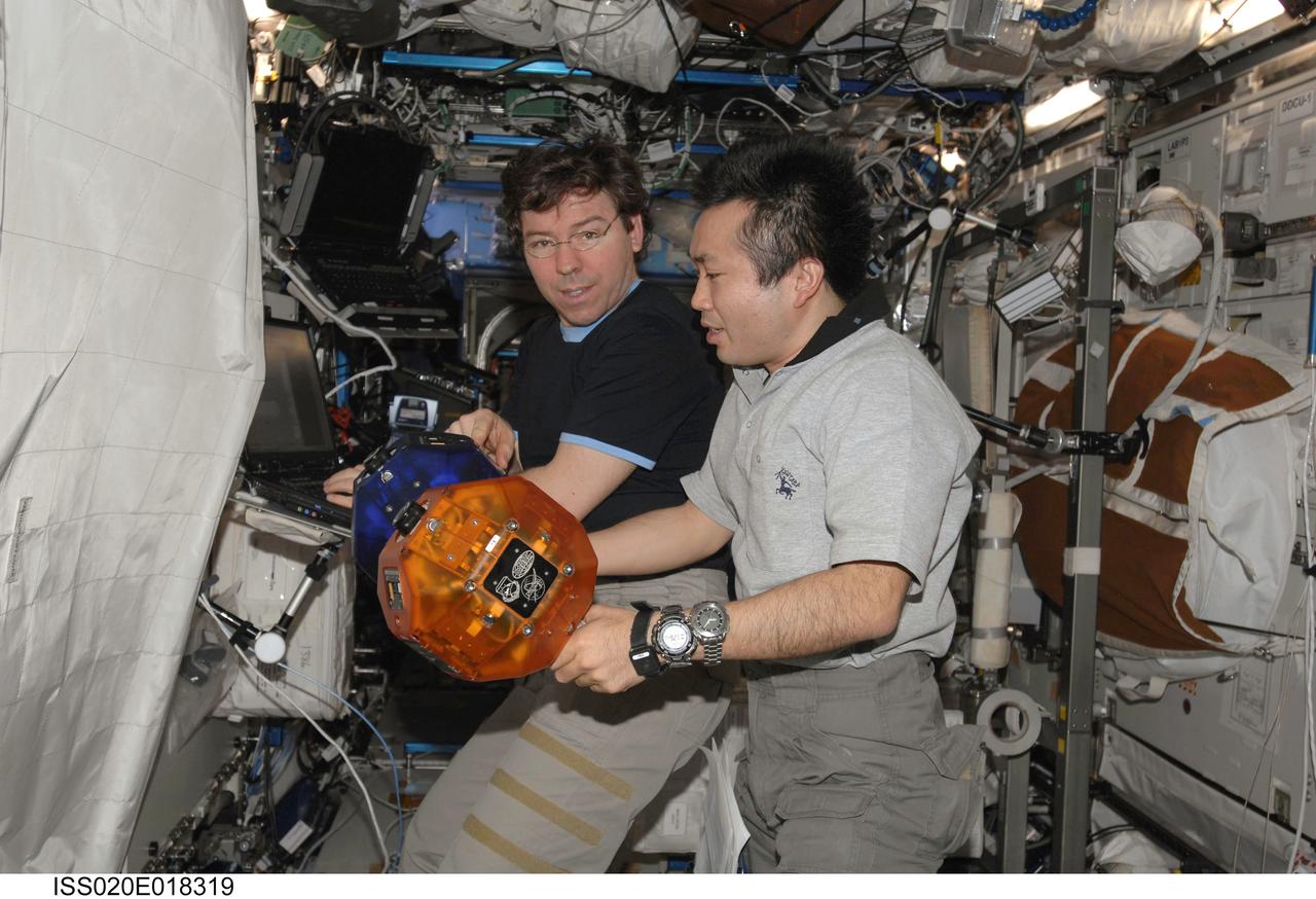 ISS020-E-018319 (11 July 2009) --- NASA astronaut Michael Barratt (left) and Japan Aerospace Exploration Agency (JAXA) astronaut Koichi Wakata, both Expedition 20 flight engineers, perform a check of the Synchronized Position Hold, Engage, Reorient, Experimental Satellites (SPHERES) Beacon / Beacon Tester in the Destiny laboratory of the International Space Station.