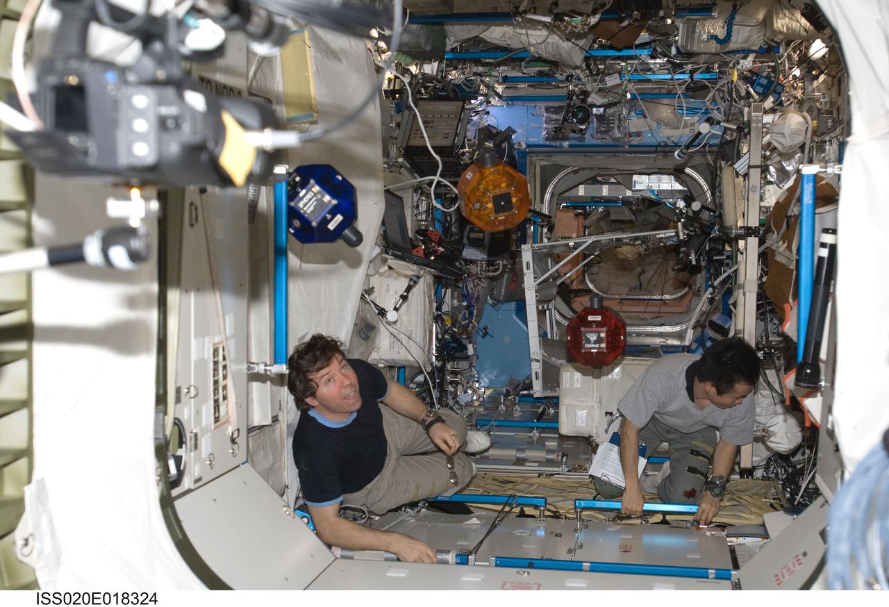 ISS020-E-018324 (11 July 2009) --- NASA astronaut Michael Barratt (left) and Japan Aerospace Exploration Agency (JAXA) astronaut Koichi Wakata, both Expedition 20 flight engineers, perform a check of the Synchronized Position Hold, Engage, Reorient, Experimental Satellites (SPHERES) Beacon / Beacon Tester in the Destiny laboratory of the International Space Station.