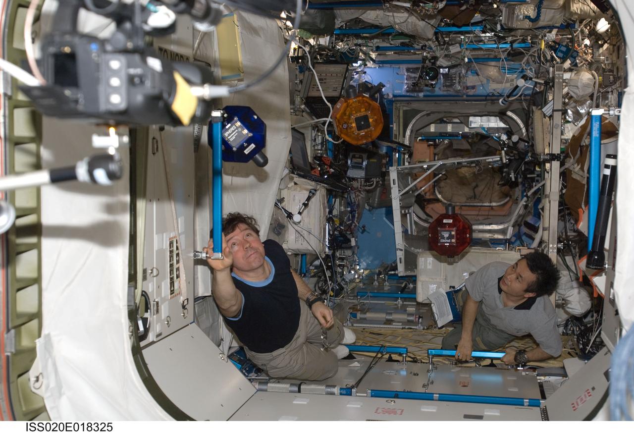 ISS020-E-018325 (11 July 2009) --- NASA astronaut Michael Barratt (left) and Japan Aerospace Exploration Agency (JAXA) astronaut Koichi Wakata, both Expedition 20 flight engineers, perform a check of the Synchronized Position Hold, Engage, Reorient, Experimental Satellites (SPHERES) Beacon / Beacon Tester in the Destiny laboratory of the International Space Station.