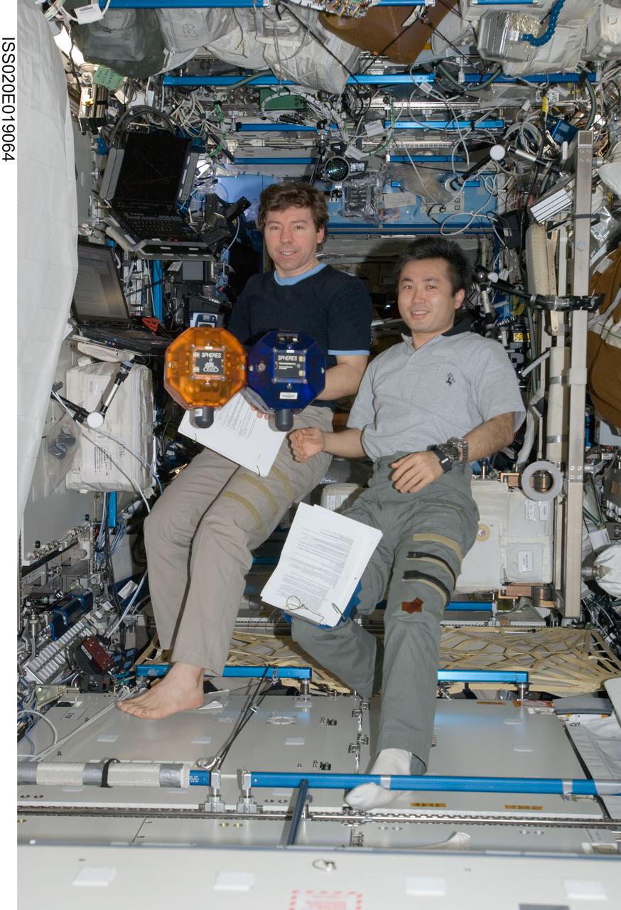 ISS020-E-019064 (11 July 2009) --- NASA astronaut Michael Barratt (left) and Japan Aerospace Exploration Agency (JAXA) astronaut Koichi Wakata, both Expedition 20 flight engineers, perform a check of the Synchronized Position Hold, Engage, Reorient, Experimental Satellites (SPHERES) Beacon / Beacon Tester in the Destiny laboratory of the International Space Station.