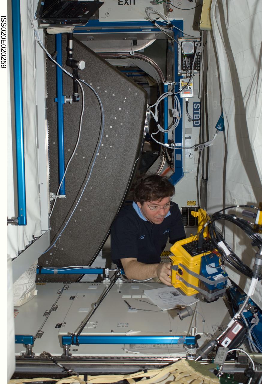 ISS020-E-020259 (8 July 2009) --- NASA astronaut Michael Barratt, Expedition 20 flight engineer, works at a rotated rack in the Destiny laboratory of the International Space Station during in-flight maintenance (IFM) to adjust the periodic flow rate of manual flow control valves for coolant loops.
