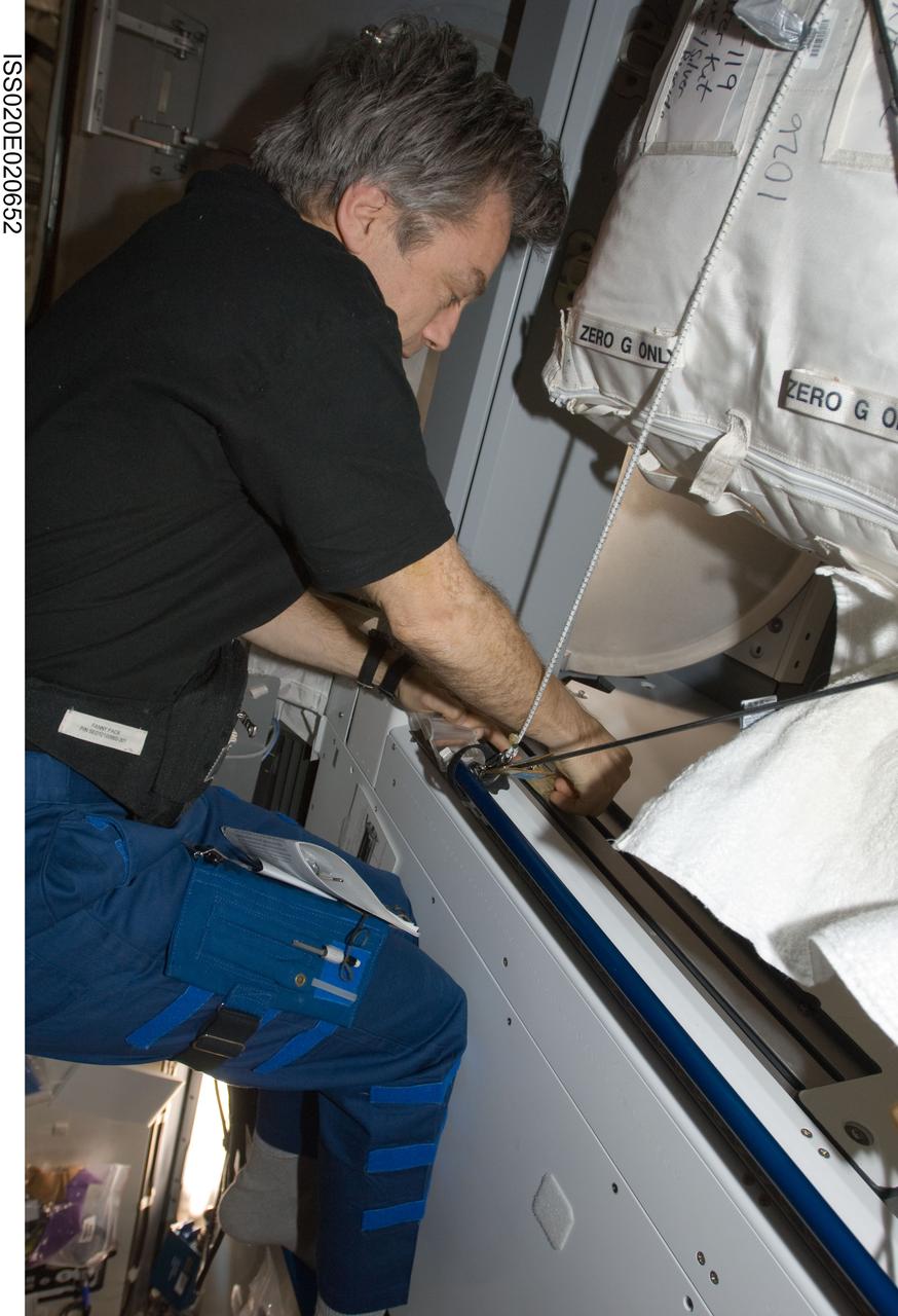 ISS020-E-020652 (15 July 2009) --- Canadian Space Agency astronaut Robert Thirsk, Expedition 20 flight engineer, uses the Surface Sample Kit (SSK) to collect microbiology samples from specific sampling locations in the Harmony node and other modules of the International Space Station.