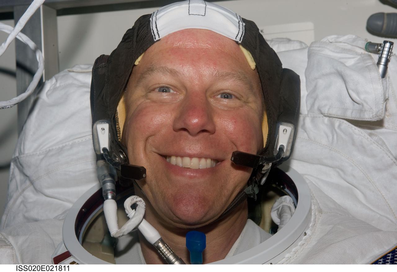 ISS020-E-021811 (18 July 2009) --- Astronaut Tim Kopra, STS-127 mission specialist converting to Expedition 20 flight engineer,  is all smiles prior to donning his helmet and  performing the final touches of suiting-up in the International Space Station's Quest airlock. He later joined astronaut Dave Wolf,  STS-127 mission specialist, for the first of five scheduled sessions of extravehicular activity, requiring four different astronauts for the outside activities.
