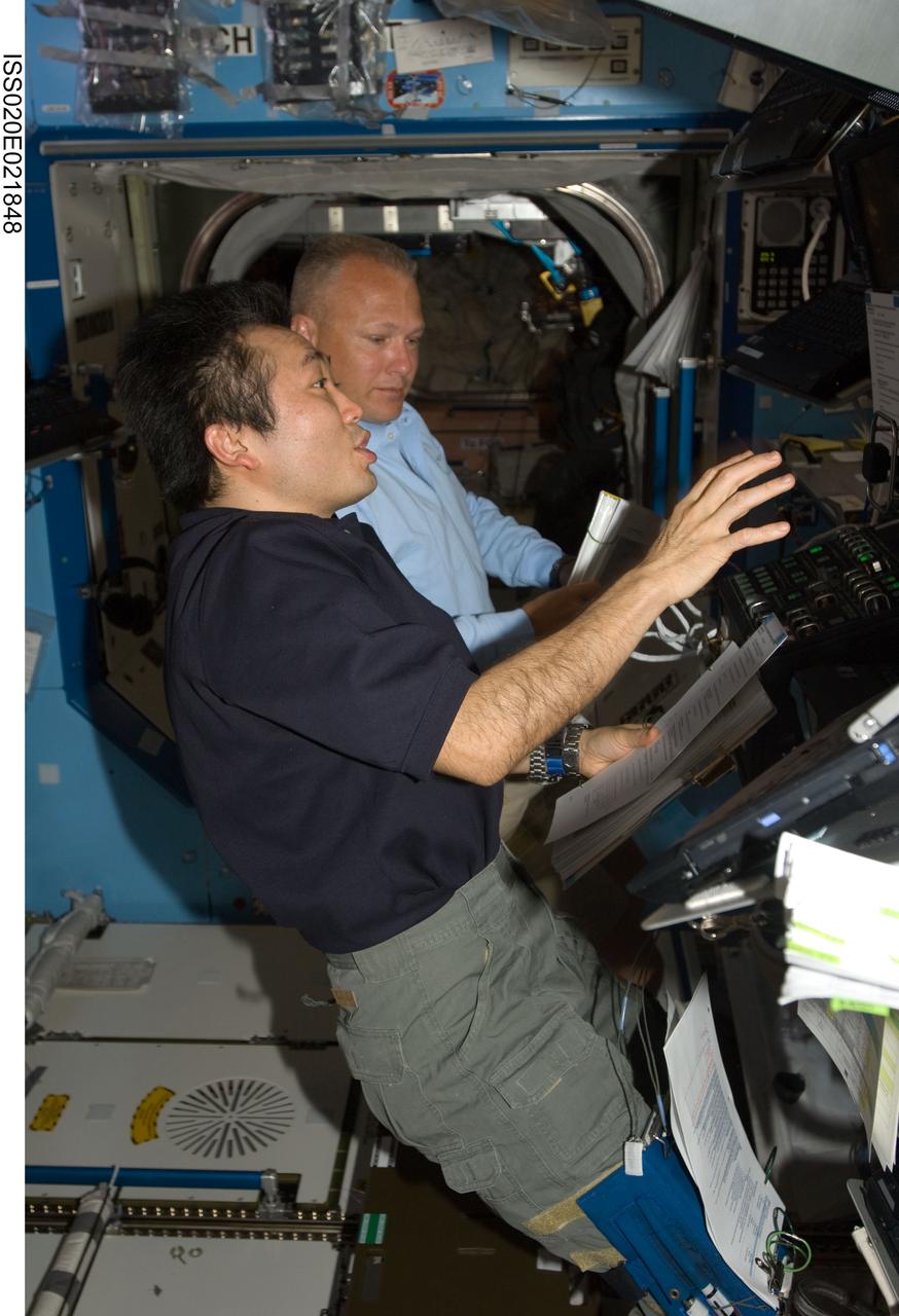 ISS020-E-021848 (18 July 2009) --- Japanese Aerospace Exploration Agency (JAXA) astronaut Koichi Wakata (right), Expedition 19/20 flight engineer, and astronaut Doug Hurley, STS-127 pilot, share intravehicular support to the first two spacewalkers who will be performing work on the International Space Station over the next week. When the Endeavour crew returns to Earth, Wakata will accompany it, having completed his current flight engineer duty during the STS-127 visit.