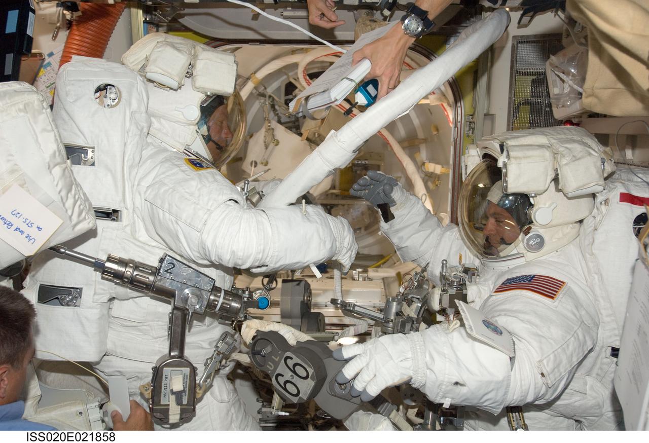 ISS020-E-021858 (18 July 2009) --- Astronauts Dave Wolf (right) and Tim Kopra are suited and just about ready to exit the International Space Station's Quest airlock to begin the first of five scheduled spacewalks over the next several days. When Wolf and six other astronauts return to Earth in the Space Shuttle Endeavour, Kopra will stay behind to serve a tour of duty on the orbital outpost.