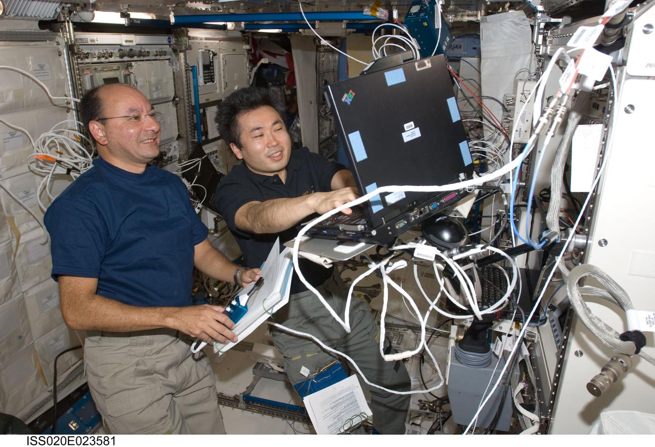 ISS020-E-023581 (23 July 2009) --- Japanese Aerospace Exploration Agency astronaut Koichi Wakata (right) and astronaut Mark Polansky, STS-127 mission specialist and commander, respectively, work in the Japanese Experiment Module or Kibo during flight day 9, as joint shuttle-station activities continue on the orbital outpost.