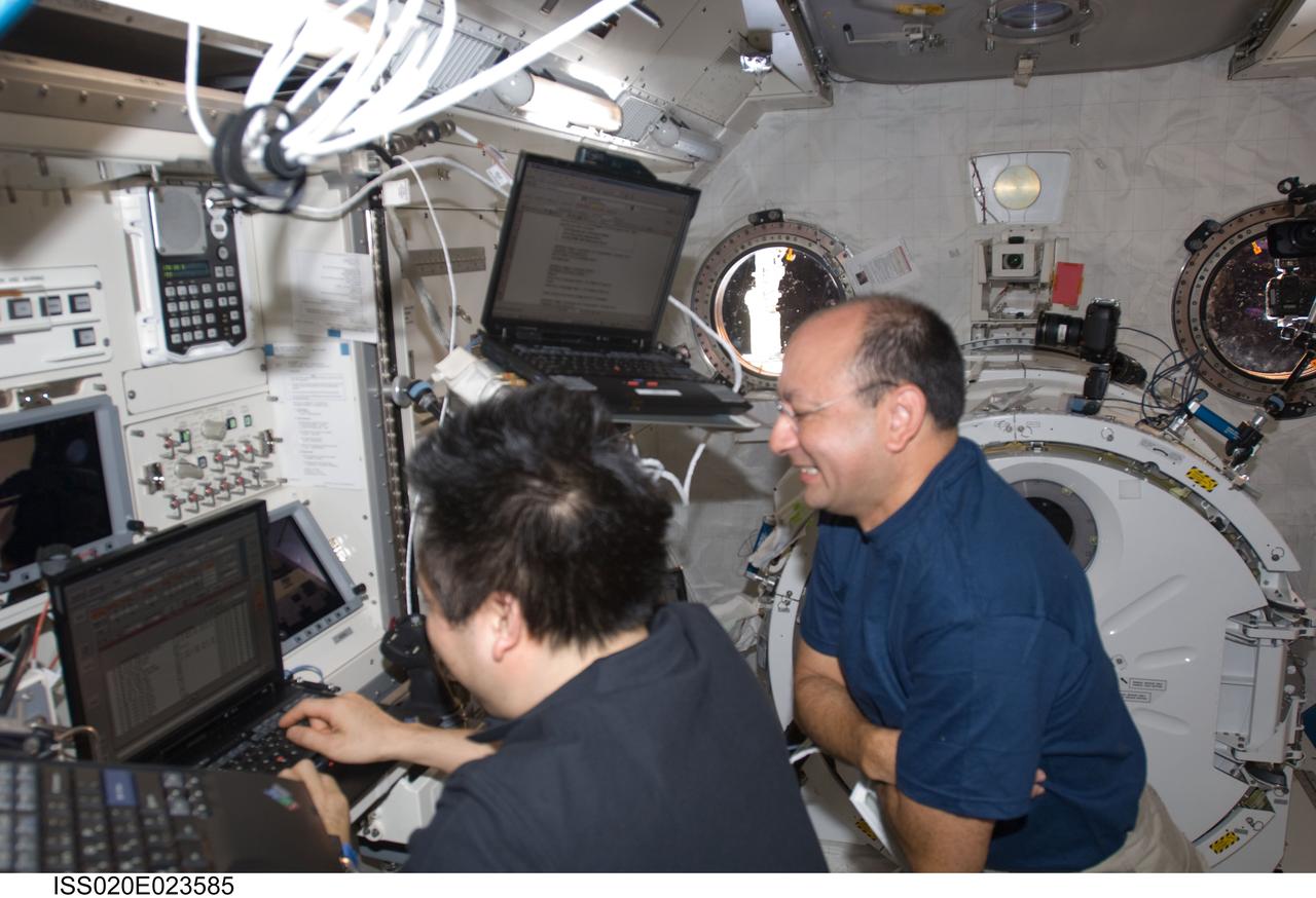 ISS020-E-023585 (23 July 2009) --- Japanese Aerospace Exploration Agency astronaut Koichi Wakata (left) and astronaut Mark Polansky, STS-127 mission specialist and commander, respectively, work in the Japanese Experiment Module or Kibo during flight day 9, as joint shuttle-station activities continue on the orbital outpost.