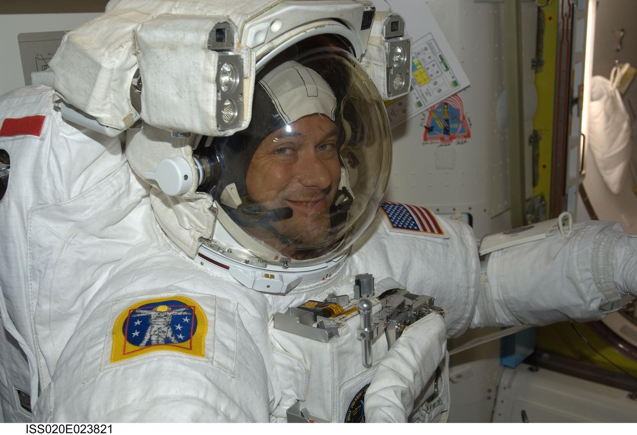 ISS020-E-023821 (24 July 2009) ---Astronaut Tom Marshburn stands suited and almost ready to participate in the July 24 flight day 10 spacewalk. He and astronaut Christopher Cassidy (out of frame) are also scheduled to wrap up the EVA work with a fifth overall session on July 27. The two mission specialists are part of a 13-member aggregation of astronauts and cosmonauts currently onboard the orbital outpost while its crew of six plays host to Endeavour's crew of seven.