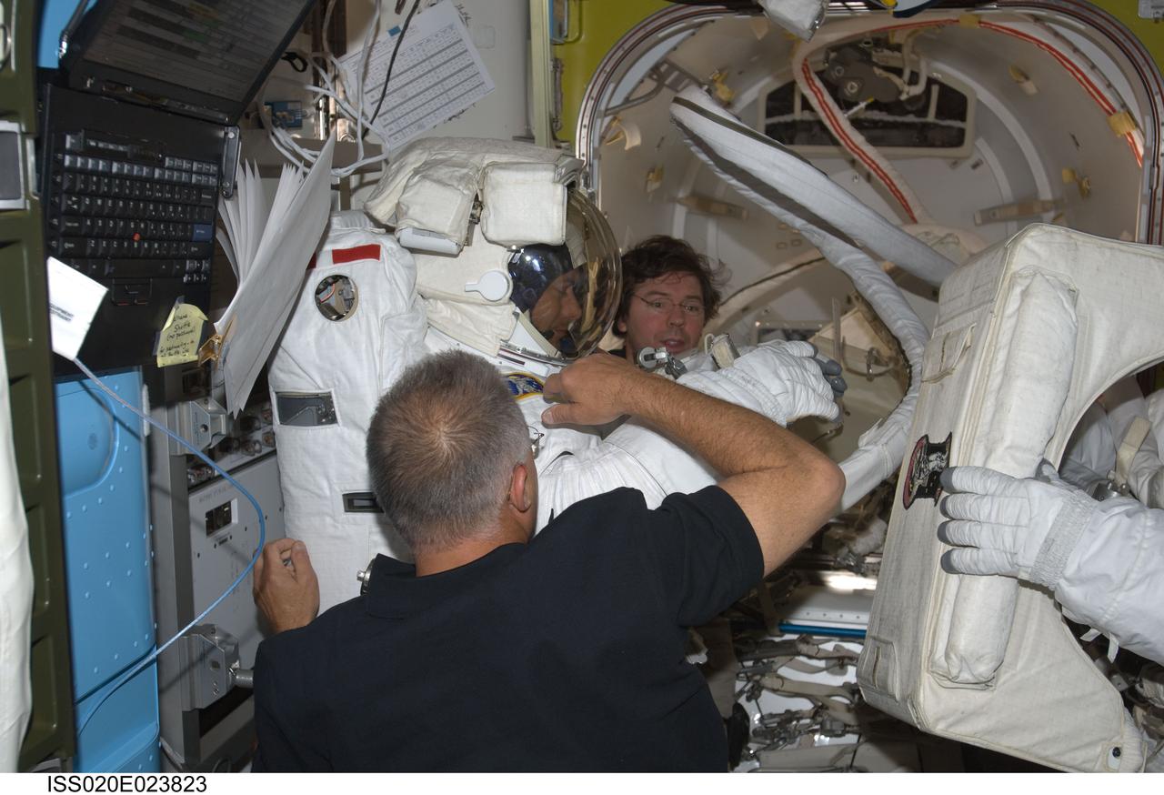 ISS020-E-023823 (24 July 2009) --- Astronauts Dave Wolf (foreground with back to camera) and Mike Barratt assist astronaut Tom Marshburn with his extravehicular mobility unit spacesuit in the joint airlock, while astronaut Christopher Cassidy (almost out of frame at right) gets ready to join him. Marshburn and Cassidy were about to participate in the July 24 flight day 10 spacewalk. They are scheduled to wrap up the EVA work with a fifth overall session on July 27. The three STS-127 mission specialists and station flight engineer are part of a 13-member aggregation of astronauts and cosmonauts currently onboard the orbital outpost while its crew of six plays host to Endeavour's crew of seven.