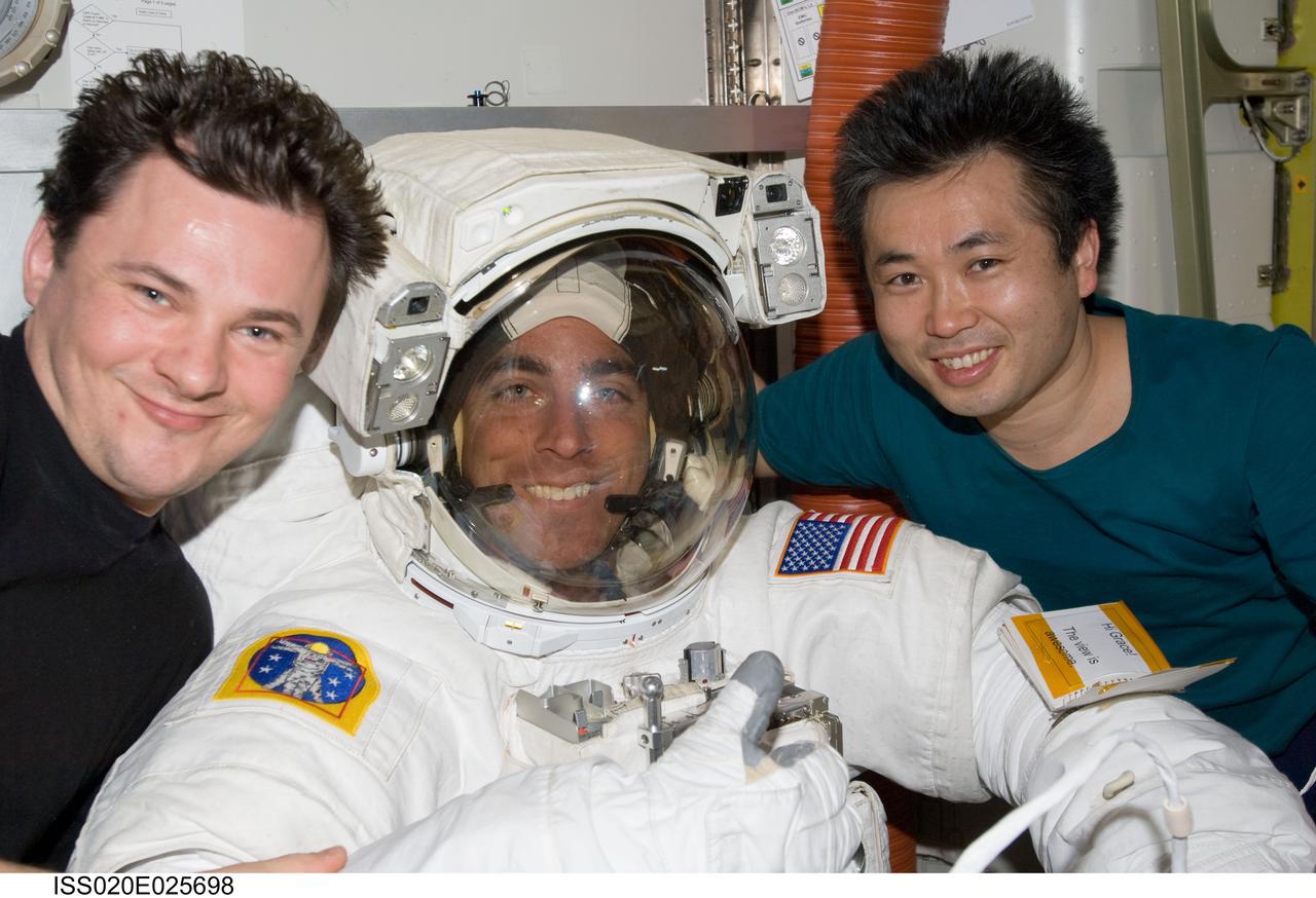 ISS020-E-025698 (27 July 2009) --- Attired in his Extravehicular Mobility Unit (EMU) spacesuit, astronaut Christopher Cassidy, STS-127 mission specialist; along with cosmonaut Roman Romanenko (left), Expedition 20 flight engineer; and Japan Aerospace Exploration Agency (JAXA) astronaut Koichi Wakata, mission specialist, are pictured in the Quest Airlock of the International Space Station as the mission's fifth and final session of extravehicular activity (EVA) draws to a close.