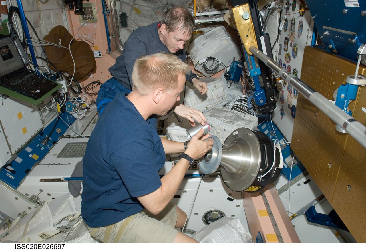 ISS020-E-026697 (31 July 2009) --- NASA astronaut Tim Kopra (foreground) and European Space Agency astronaut Frank De Winne, both Expedition 20 flight engineers, work with a carbon dioxide removal kit adapter in the Unity node of the International Space Station.