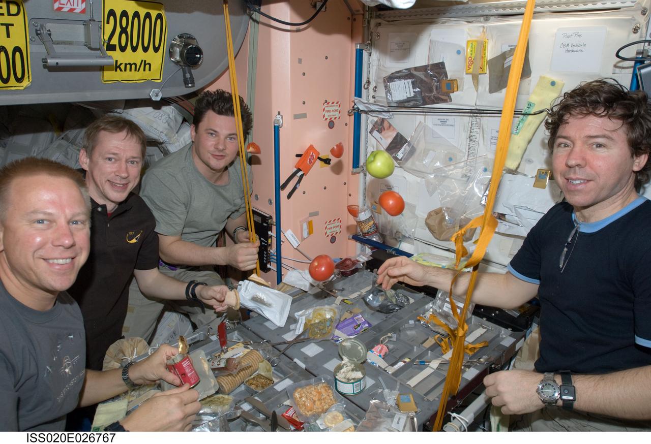 ISS020-E-026767 (31 July 2009) --- NASA astronaut Tim Kopra (left), European Space Agency astronaut Frank De Winne, cosmonaut Roman Romanenko and NASA astronaut Michael Barratt, all Expedition 20 flight engineers, share a meal at a galley in the Unity node of the International Space Station.