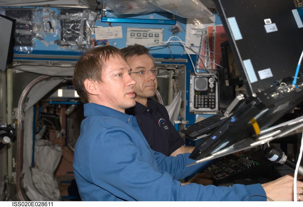 ISS020-E-028611 (7 Aug. 2009) --- European Space Agency astronaut Frank De Winne (foreground) and Canadian Space Agency astronaut Robert Thirsk, both Expedition 20 flight engineers, work the controls of the Space Station Remote Manipulator System (SSRMS) and the Centerline Berthing Camera System (CBCS) in the International Space Station’s Destiny laboratory to relocate the Pressurized Mating Adapter 3 (PMA-3) from the Unity node nadir port to Unity’s port side. This relocation is required to allow reconfigurations on the side of the Unity node port bulkhead by the crew in a pressurized environment where PMA-3 is now located. Once these reconfigurations are completed, PMA-3 will be relocated back to Unity’s nadir port, after which the Tranquility node will be brought up and berthed to Unity’s port side on mission STS-130/20A.