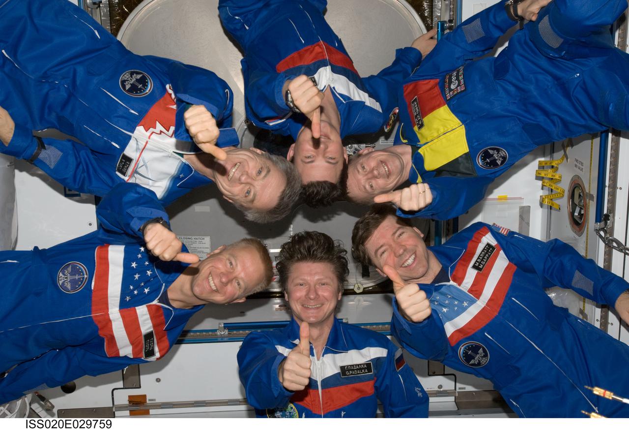ISS020-E-029759 (10 Aug. 2009) --- Expedition 20 crew members give a “thumbs-up” signal as they pose in "star-burst" formation for an in-flight portrait in the Harmony node of the International Space Station. Pictured clockwise from the bottom (center) are cosmonaut Gennady Padalka, commander; NASA astronaut Tim Kopra, Canadian Space Agency astronaut Robert Thirsk, cosmonaut Roman Romanenko, European Space Agency astronaut Frank De Winne and NASA astronaut Michael Barratt, all flight engineers.
