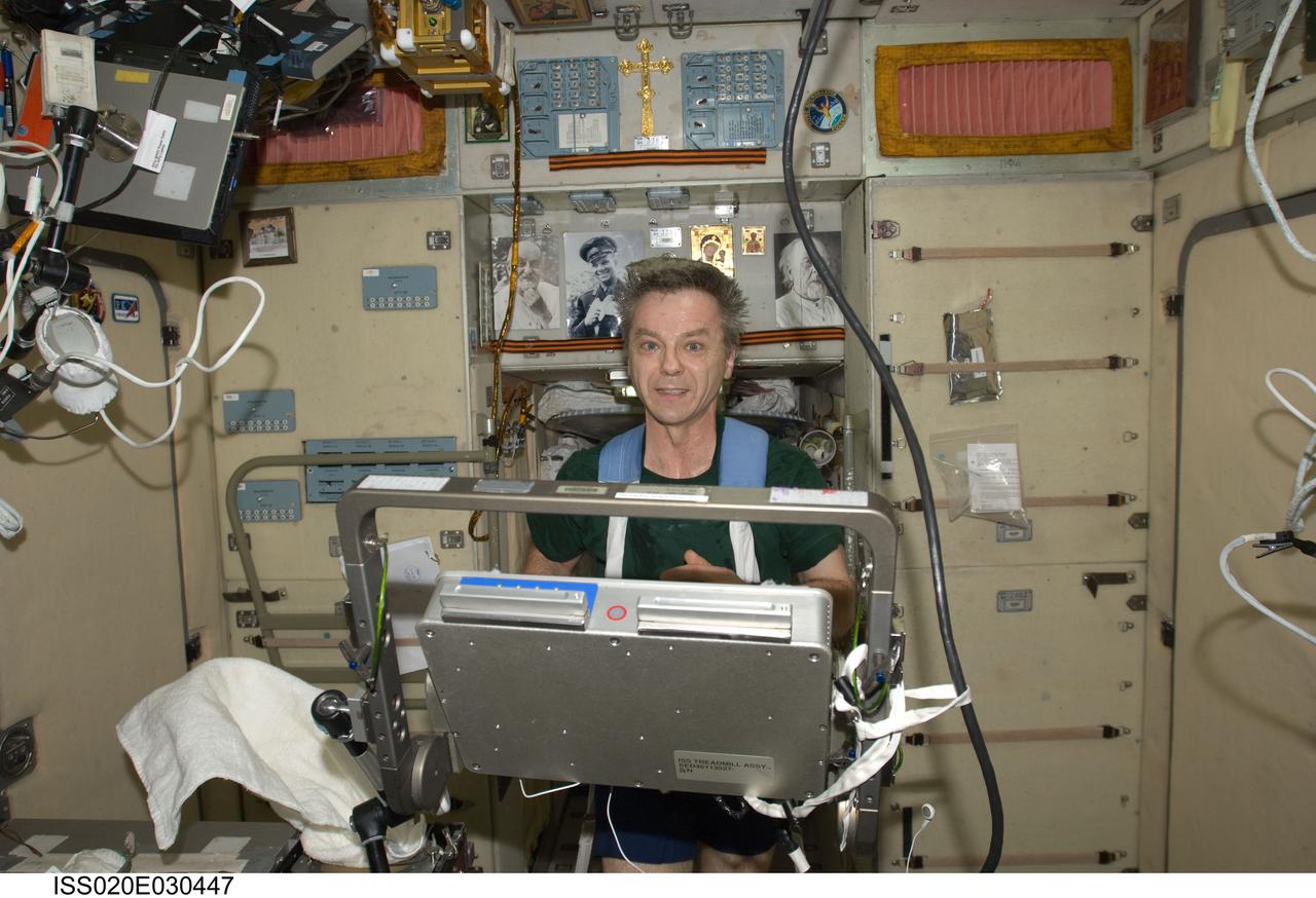 ISS020-E-030447 (13 Aug. 2009) --- Canadian Space Agency astronaut Robert Thirsk, Expedition 20 flight engineer, equipped with a bungee harness, exercises on the Treadmill Vibration Isolation System (TVIS) in the Zvezda Service Module of the International Space Station.