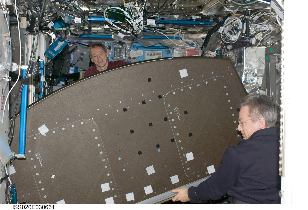 ISS020-E-030661 (13 Aug. 2009) --- Canadian Space Agency astronaut Robert Thirsk (right) and European Space Agency astronaut Frank De Winne, both Expedition 20 flight engineers, prepare to relocate the Crew Health Care System (CHeCS) rack in the Destiny laboratory to the Kibo laboratory of the International Space Station.