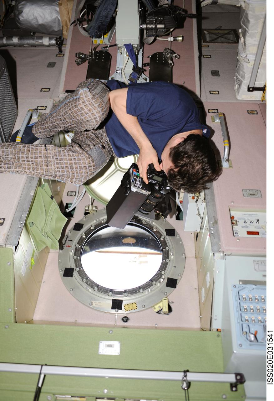 ISS020-E-031541 (19 Aug. 2009) --- Cosmonaut Roman Romanenko, Expedition 20 flight engineer, uses science hardware RUSALKA at a window in the Zvezda Service Module of the International Space Station to take methane and carbon dioxide measurements in Earth’s atmosphere at sunset.