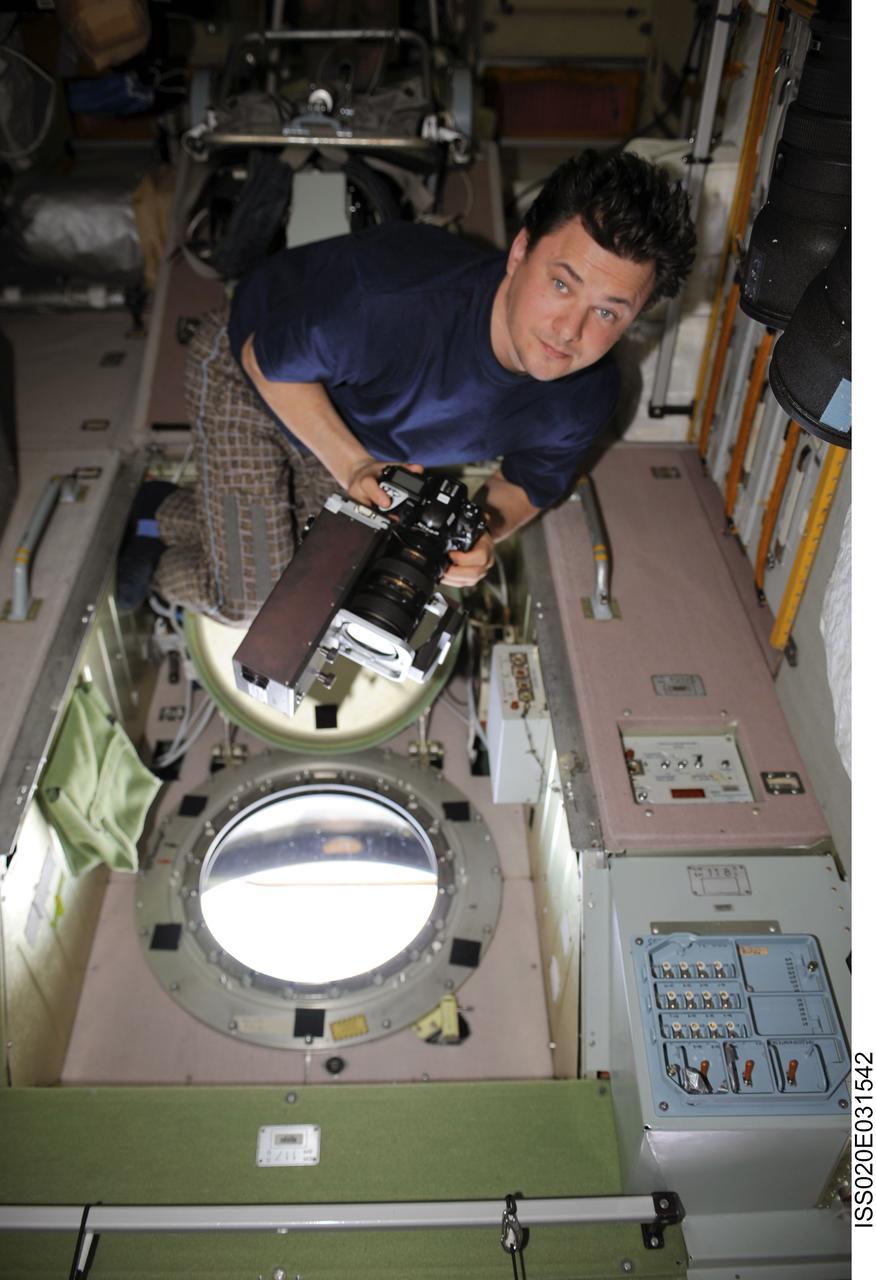 ISS020-E-031542 (19 Aug. 2009) --- Cosmonaut Roman Romanenko, Expedition 20 flight engineer, uses science hardware RUSALKA at a window in the Zvezda Service Module of the International Space Station to take methane and carbon dioxide measurements in Earth’s atmosphere at sunset.
