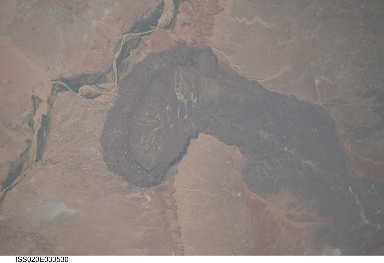 ISS020-E-033530 (21 Aug. 2009) --- Black Point Lava Flow in northern Arizona, seen in this image photographed by an Expedition 20 crew member on the International Space Station, is an excellent setting for training and systems testing for future exploration missions to the moon. Seen from space, the other-worldly footprint of the dark black basaltic lava creates a striking landscape. The flow is part of Arizona?s San Francisco Volcanic Field, a group of geologically young (approximately 6 million to less than one thousand years old, according to scientists) volcanoes, flows and cinder cones located just north of Flagstaff, Arizona.  Scientists believe when it erupted onto the surface, the Black Point Lava flowed eastward over the older Permian and Triassic sedimentary rock sequences (spanning the period from roughly 300 to 240 million years ago) that are so well known around the vicinity of the Grand Canyon. The eastern edge of the flow slumps down to the surrounding plain, and ends along the Little Colorado River (upper left). In late August and early September 2009, scientists and engineers from NASA and several universities will travel to the Black Point Lava Flow to conduct tests for NASA?s Lunar Electric Rover (LER). This year, a team of geologists will support the tests, simulating traverses that might occur on the moon.